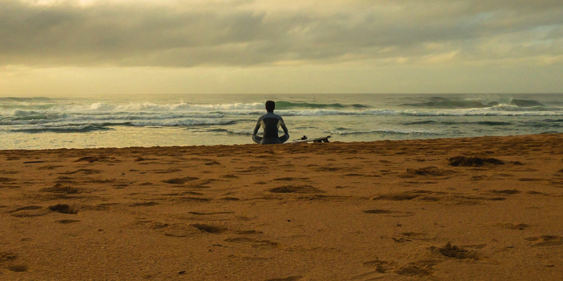 Person meditating on beach